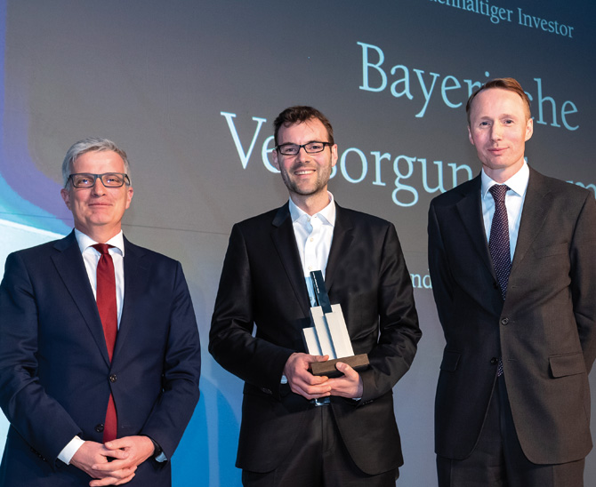 Kees-Jan van de Kamp von NN Investment Partners (r.) überreichte den Award an Andreas Hallermeier, vom ­Juryvorsitzenden Rolf Häßler (l.) kam die Begründung für die Auszeichnung. (Bild: Andreas Schwarz)